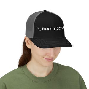 May include: A black and gray trucker hat featuring a structured front panel with the white text ">_ ROOT ACCESS" embroidered across the center. The cap includes a solid black brim and a breathable gray mesh back panel with a classic snapback closure.