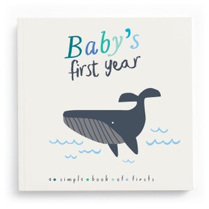 May include: A light blue and white book with the text "Baby's first year" and a cartoon whale illustration. The book also has the text "a simple book of firsts".