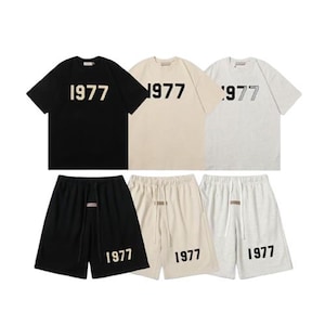 May include: Three sets of short-sleeved t-shirts and matching shorts in black, beige, and light gray. Each t-shirt features the number 1977 printed on the chest, and each pair of shorts features the number 1977 printed on the lower left leg.