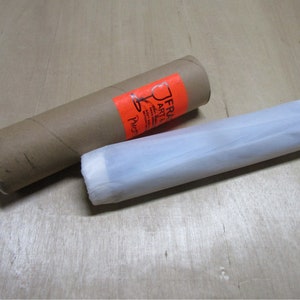 May include: A brown cardboard tube with a white label that says "FRA ART" and a white tissue paper tube.