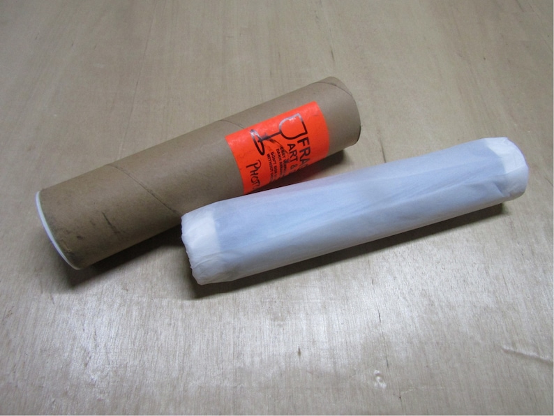 May include: A brown cardboard tube with a white label that says "FRA ART" and a white tissue paper tube.
