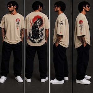 May include: A beige short-sleeve t-shirt featuring a red sun and Japanese text on the chest. The back displays a samurai, a demon mask, and a torii gate. The sleeves feature a circular emblem and a bamboo illustration with red sun accents.