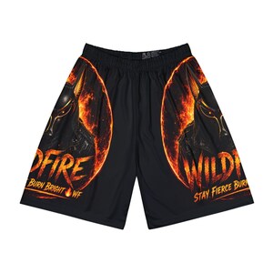 May include: Black athletic shorts featuring a graphic of a dark canine figure surrounded by orange and yellow flames. The text "WILDFIRE" and "STAY FIERCE BURN BRIGHT WF" is printed in a fiery orange font on both legs of the shorts.