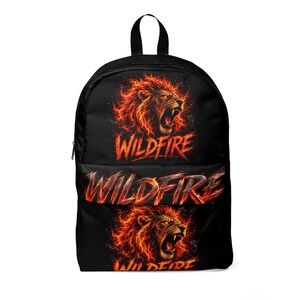 Peut inclure: Un sac à dos noir orné d'un motif représentant un lion rugissant avec une crinière enflammée. Le mot WILDFIRE est imprimé dans une police orange et rouge stylisée au-dessus et au-dessous du lion, et répété sur le rabat de la poche avant.