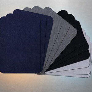 May include: A collection of rectangular fabric patches arranged in a fan shape. The set includes multiple pieces in shades of navy blue, dark gray, black, and light gray, all featuring a visible woven twill texture and rounded corners.