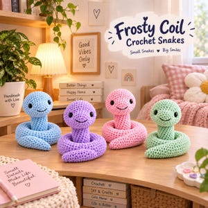 Puede incluir: Cuatro serpientes de ganchillo en azul claro, morado, rosa y verde menta están dispuestas sobre una superficie de madera. Cada peluche tiene un cuerpo en espiral, cabeza redondeada y ojos y boca bordados en negro. Texto Frosty Coil arriba.