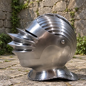 May include: A polished steel knight's helmet featuring a multi-layered visor with three horizontal ventilation slits and a pointed front. The rounded dome is constructed from overlapping metal plates, and the base includes a flared neck guard.