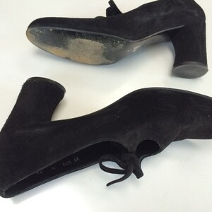 May include: A pair of black suede heeled shoes with a lace-up detail. The shoes have a chunky heel and a rounded toe. The size is marked as "37 2 1/2 37".