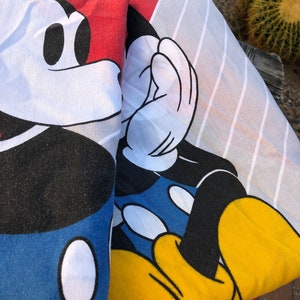 May include: A red, white, and blue Mickey Mouse print fabric. The fabric features a close-up of Mickey Mouse's face and hand.
