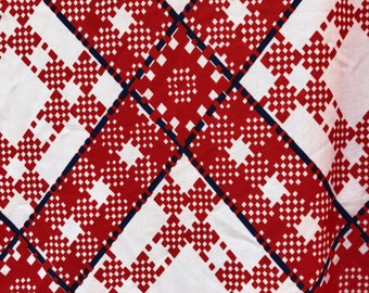 May include: Red and white checkered fabric with a blue and white border. The fabric has a geometric pattern.