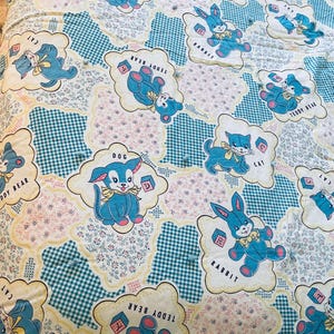May include: A white and blue fabric with a repeating pattern of cartoon animals and the words "Teddy Bear", "Dog", "Cat", and "Rabbit".