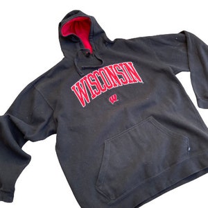 May include: Black hooded sweatshirt with a red "WISCONSIN" logo and a red Badger mascot logo. The sweatshirt has a kangaroo pocket.