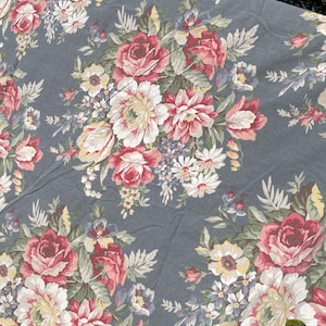 May include: A gray fabric with a floral pattern featuring pink, white, and yellow roses, and green leaves.