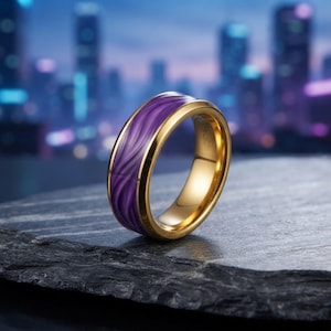 May include: A gold-toned band ring featuring a smooth, polished finish on the edges and a central inlay of deep purple material with a swirling, wave-like pattern that wraps around the entire circumference of the circular jewelry piece.