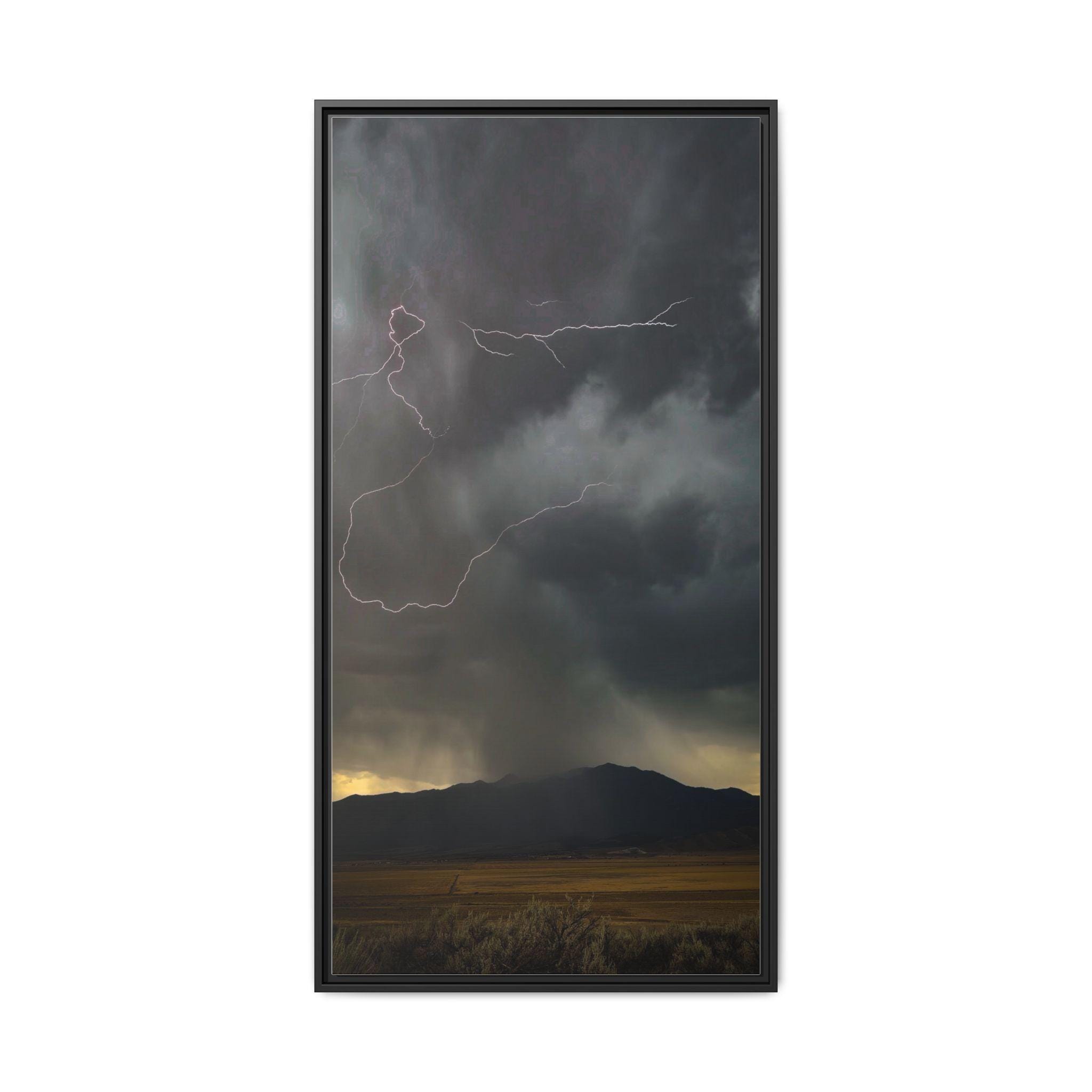 Branches of lightning across dark storm clouds above a mountain ridge, with golden light along the horizon.