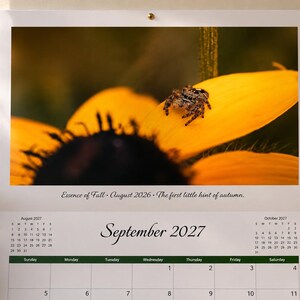 May include: A wall calendar for September 2027 featuring a photograph of a small spider resting on a bright yellow flower petal. The text "Essence of Fall - August 2026 - The first little hint of autumn" is printed below the image above the calendar grid.