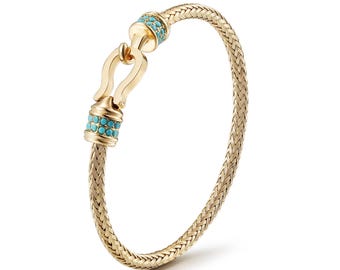 May include: Gold-toned bracelet with a woven design. The bracelet features a hook clasp and is adorned with turquoise-colored stones. The overall design is elegant and suitable for everyday wear or special occasions.