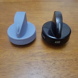 May include: Two circular stove control knobs, one light blue and one black. Both knobs feature a raised vertical handle and the word OFF printed on the side. The black knob also includes the word LITE printed on its side near the handle.