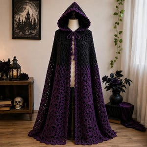 May include: A floor-length hooded cloak featuring a two-tone crochet design. The upper section is solid black, while the lower portion transitions into a deep purple with an intricate, open-work lace pattern. It includes a matching tie closure.