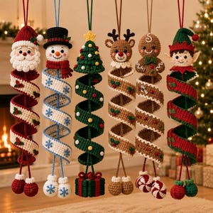 May include: Six hanging crochet Christmas ornaments featuring a Santa Claus, a snowman, a Christmas tree, a reindeer, a gingerbread person, and an elf. Each figure is attached to a long, spiralling, colourful crocheted ribbon with small decorative accents.