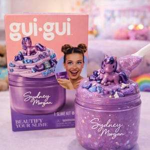 May include: A gui-gui brand slime kit featuring a purple jar of glittery slime topped with a small purple pony figurine and various charms. The packaging box displays the product name, the name Sydney Morgan, and an image of a person holding the jar.