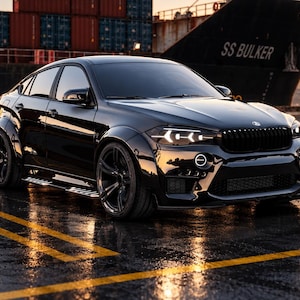 May include: A glossy black SUV with a wide-body kit, tinted windows, and custom multi-spoke wheels. The vehicle features a signature kidney grille and LED headlights. A purple and white logo in the bottom left corner reads SM GARAGE.