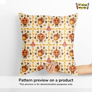May include: A square throw pillow featuring a repeating autumn-themed pattern on a cream background. The design includes orange jack-o'-lanterns, brown acorns, red maple leaves, small black bows, and orange, yellow, and white candy corn pieces.