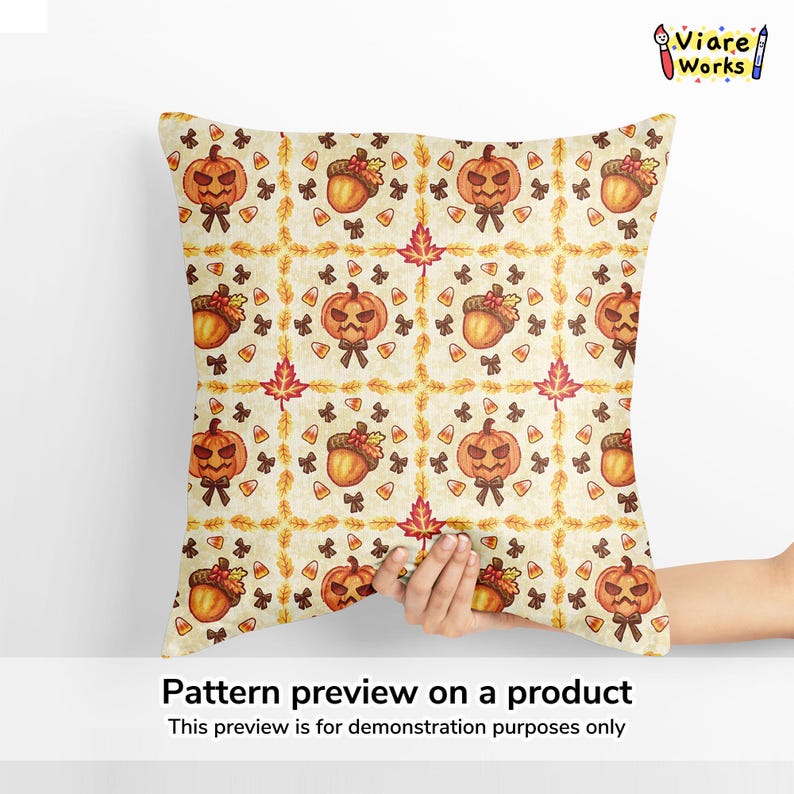 May include: A square throw pillow featuring a repeating autumn-themed pattern on a cream background. The design includes orange jack-o'-lanterns, brown acorns, red maple leaves, small black bows, and orange, yellow, and white candy corn pieces.