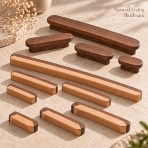 Puede incluir: Una colección de tiradores y manijas de madera para armarios en varias longitudes y formas. Algunas piezas son de madera marrón oscura sólida, mientras que otras presentan un diseño bicolor con madera clara y marrón oscura. El texto Natural Living Hardware es visible.