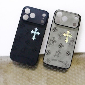 Puede incluir: Dos fundas rectangulares para smartphone con un patrón de cruces repetido. La funda izquierda es de color negro mate con una cruz plateada. La funda derecha es de color gris translúcido con una cruz dorada y motivos de cruces negras.