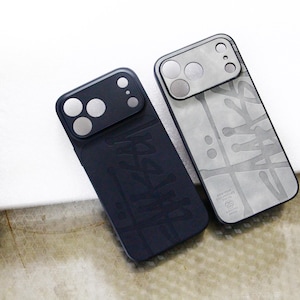 Puede incluir: Dos fundas rectangulares para smartphone con abertura para la cámara. Una funda es de color negro mate con un logotipo sutil estilo grafiti. La otra es de color gris claro con un logotipo estilo grafiti gris oscuro y un marco de cámara metálico.