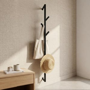 May include: A vertical black metal wall-mounted coat rack featuring five angled hooks. A beige fabric tote bag hangs from one hook, and a straw hat with a wide brim is suspended from another hook, showcasing a functional storage solution.