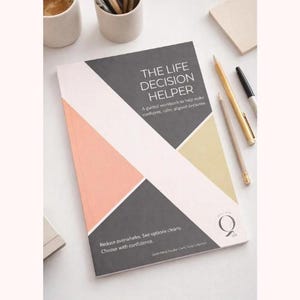 May include: A rectangular workbook titled The Life Decision Helper with a geometric cover design in charcoal gray, soft peach, and muted gold. The cover features white text, a circular logo, and the subtitle A guided workbook to help make confident, calm, aligned decisions. Reduce overwhelm. See options clearly. Choose with confidence.