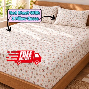 May include: A bed sheet set featuring a white base with a small-scale floral pattern in shades of pink, orange, and green. The set includes a fitted sheet and two matching pillowcases. The text Bed Sheet With 2 Pillow Cases is visible.