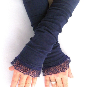 Puede incluir: Un par de calentadores de brazos azul marino con ribete de encaje. Los calentadores de brazos están hechos de una tela suave y elástica, perfectos para mantener los brazos calientes en los meses más fríos.