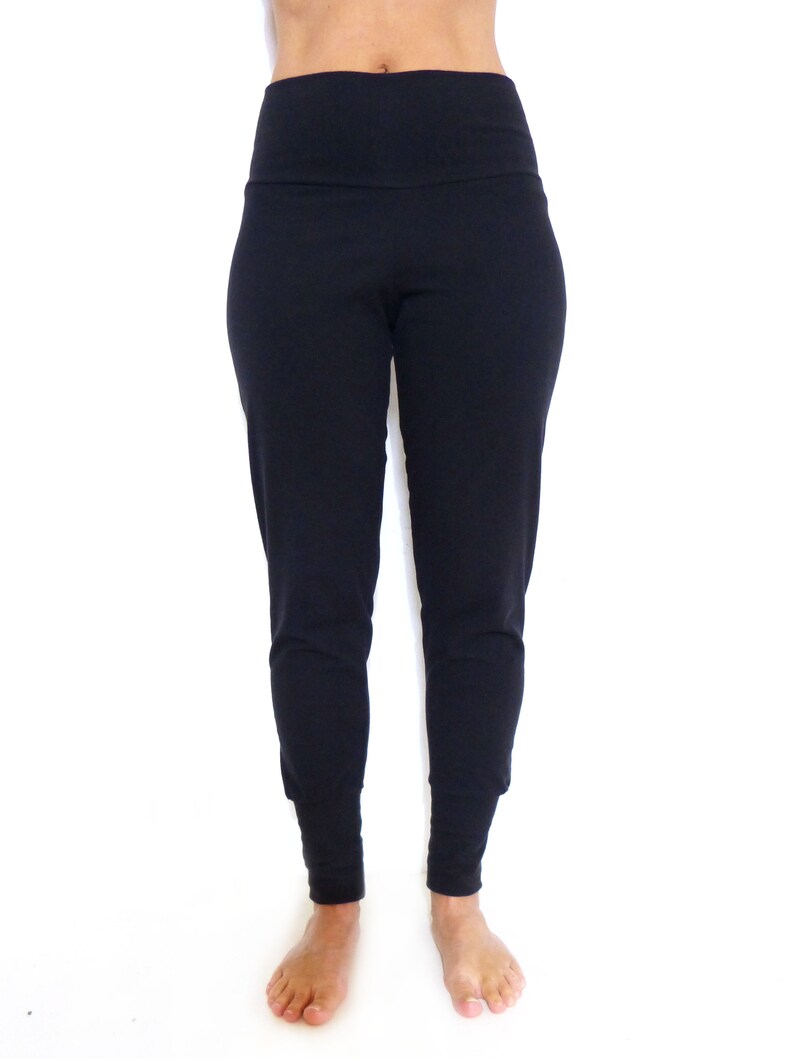 Puede incluir: Pantalones de yoga negros de cintura alta con una cintura ancha.