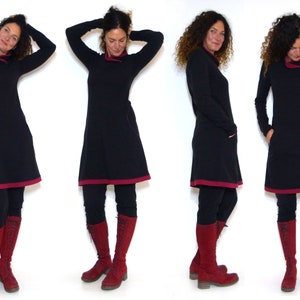 Puede incluir: Un vestido negro con ribete burdeos y mangas largas. El vestido est&aacute; ajustado a la cintura y se ensancha en el dobladillo. La modelo lleva leggings negros y botas burdeos.
