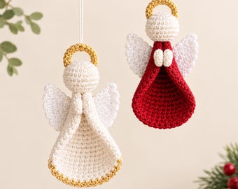 Puede incluir: Dos adornos de ángeles tejidos a ganchillo que cuelgan de hilos blancos. Un ángel es blanco con un halo dorado y borde dorado en la base. El segundo ángel tiene un vestido rojo oscuro, alas blancas y un halo dorado. Manos blancas pequeñas.