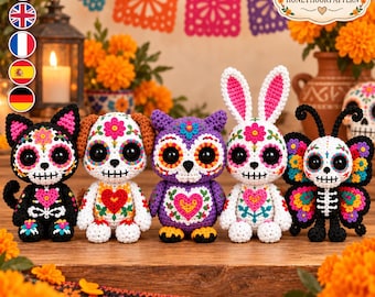 May include: Five crocheted amigurumi figures featuring Day of the Dead skull motifs: a black cat, a white dog, a purple owl, a white rabbit, and a black butterfly. Each figure displays colorful floral patterns, heart designs, and stitched facial details.