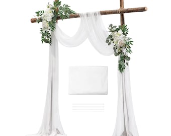 May include: A wooden arch frame featuring a horizontal beam and two vertical posts, draped with sheer white fabric. Two floral arrangements consisting of white flowers and green leaves are attached to the top corners of the wooden structure.