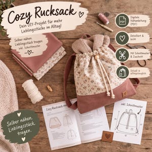 Könnte beinhalten: Ein DIY-Nähset für einen Rucksack mit Kordelzug in Altrosa und Blumenmuster. Enthält eine gedruckte Anleitung mit Skizzen und 61 cm Maßangaben, Stoffzuschnitte, Garnrolle und einen Nahttrenner für das Nähprojekt.