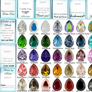 May include: A chart of 36 teardrop-shaped crystals in various colors, with a note card above each crystal listing the color name. The note cards also include text messages for different occasions, such as "Thank you for being my bridesmaid!" and "Will you be my bridesmaid?"