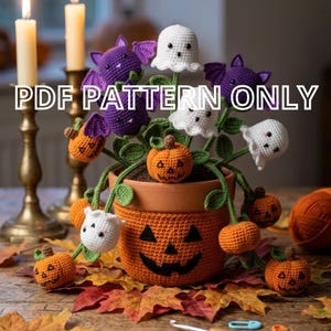May include: A crochet potted plant featuring purple bats, white ghosts, and orange jack-o'-lanterns with green stems and leaves. The terracotta-colored pot has a jack-o'-lantern face. Text reads PDF PATTERN ONLY. Includes crochet hook and markers.