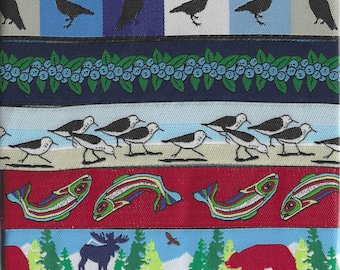 May include: A colorful ribbon featuring various nature-themed patterns. Designs include black birds on blue and white stripes, blueberries, shorebirds, salmon, a moose, a bear, and evergreen trees. The ribbon is suitable for crafts and decorative projects.