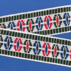 Op de afbeelding: Witte geweven trim met een herhalend patroon van rode, blauwe en groene cirkels. De trim is gemaakt van een dik, duurzaam materiaal en heeft een licht getextureerd oppervlak.