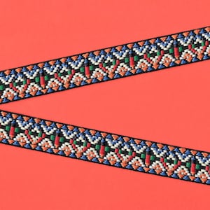 May include: Black and orange trim with a geometric pattern in shades of blue, red, green, and white. The trim is on a bright orange background.