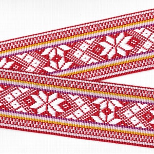 May include: Red, white, purple, and gold woven ribbon with a geometric pattern. The ribbon is made of a soft, textured fabric.