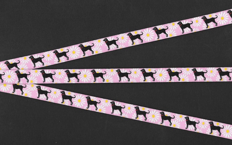 May include: Three pink ribbons with black silhouettes of dogs and white daisies printed on them.