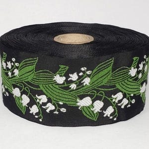 Ruban jacquard KAFKA H-02/21, bordure en coton tissé biologique de 38 mm (1-1/2 po.) de large, fond noir, muguet blanc et feuilles vertes