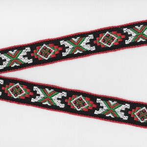 May include: Black, red, green, and white woven trim with a geometric pattern.
